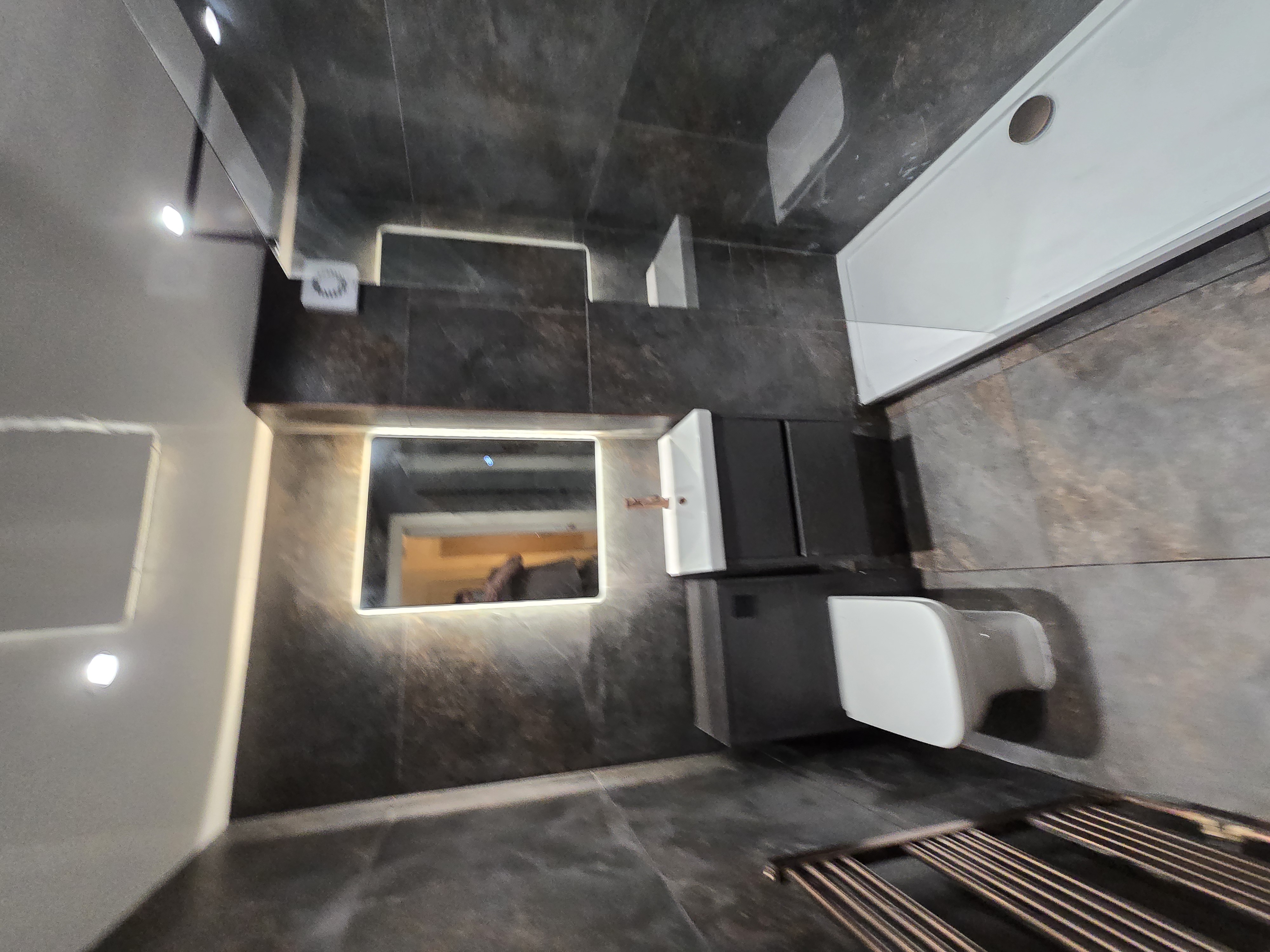 Dark slate bathroom with LED mirror and walk-in shower